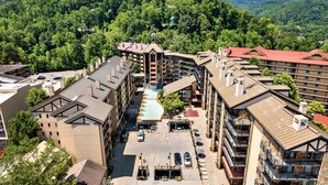 A hotel with multiple floors, a central courtyard, and a mountain backdrop. - Gatlinburg Town Square (Gatlinburg)