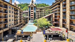 Un hotel de varios pisos con balcones, una fuente central y fachada de piedra.