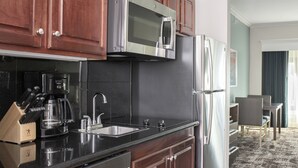 Una cocina moderna con armarios de madera, electrodomésticos de acero inoxidable y una encimera negra.