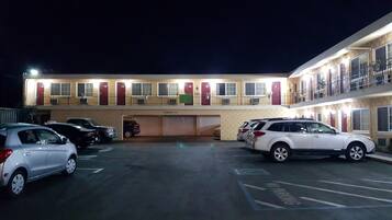 Um motel com vários andares e estacionamento.