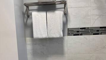 Un baño con inodoro, lavamanos, ducha y bañera.