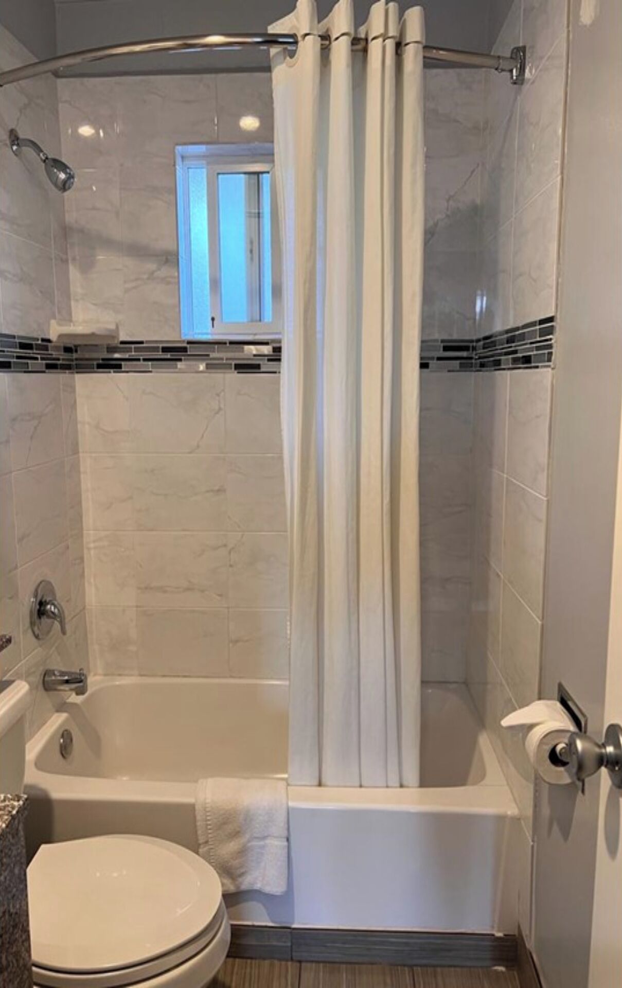 Une salle de bain avec une baignoire, des toilettes et un rideau de douche.