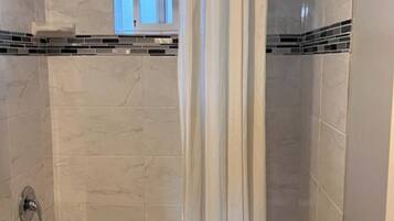 Une salle de bain avec une baignoire, des toilettes et un rideau de douche.