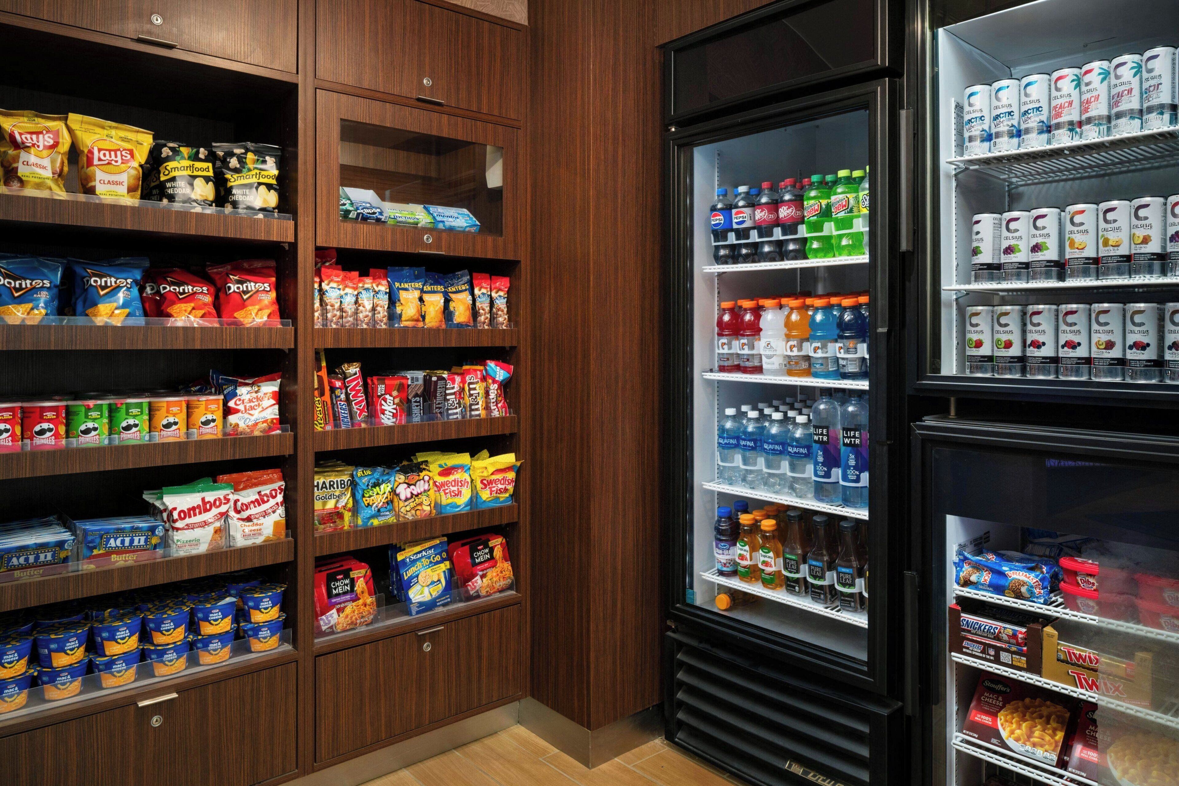 Un espace proposant des distributeurs automatiques de collations et de boissons, avec un assortiment varié de produits.