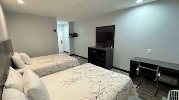 Una habitación de hotel con dos camas, televisión, escritorio y vestidor.