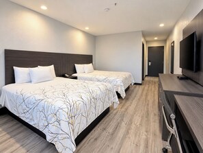 Een hotelkamer met twee bedden, een bureau en een televisie.
