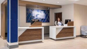 A modern reception desk with a blue accent wall and a geometric design.
