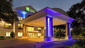 A Holiday Inn Express hotel with a modern design, featuring a covered entrance and illuminated signage.