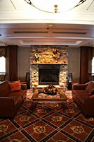 A living room with a fireplace, patterned carpet, and two sofas.