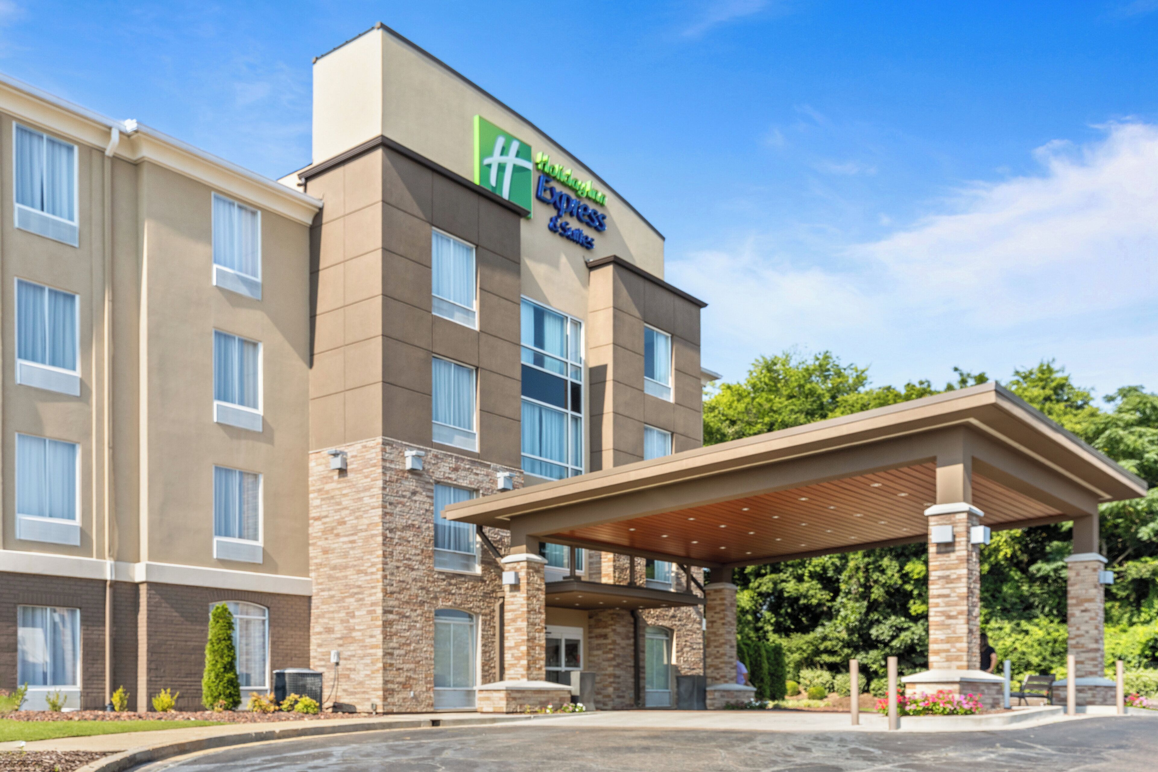 A hotel with a modern design, featuring a covered entrance and a prominent sign.