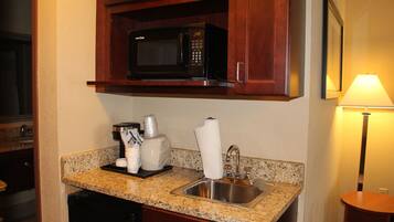 A kitchen with a microwave, sink, and countertop.