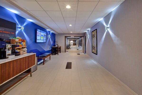 A hotel lobby with a reception desk, seating area, and a long corridor leading to the rooms. - Holiday Inn Express & Suites Absecon-Atlantic City by IHG (Absecon)
