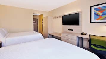 Quarto de hotel com duas camas, televisão, escrivaninha e uma cadeira.