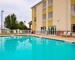 Un hotel con piscina, zona de estar al aire libre y fachada de ladrillo.
