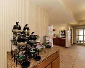 A kitchen area with a coffee station featuring multiple coffee makers and a refrigerator. - Quality Inn Spring Mills - Martinsburg North (Falling Waters)