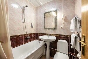 A bathroom with a bathtub, sink, and toilet.
