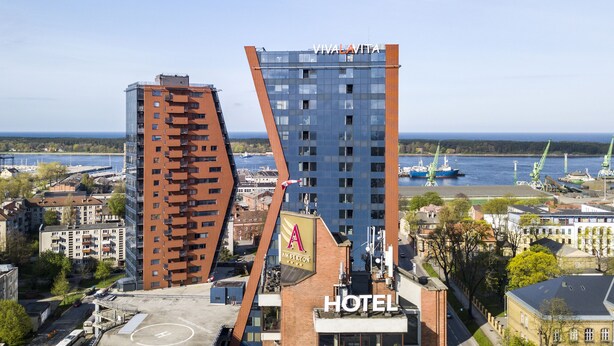 A hotel with a modern design, located near a waterfront with a view of the sea. - Amberton Hotel Klaipeda (Klaipeda)