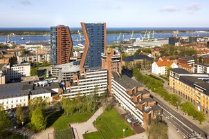 Hotel com design moderno, situado em área urbana com vista para o mar e outros edifícios.