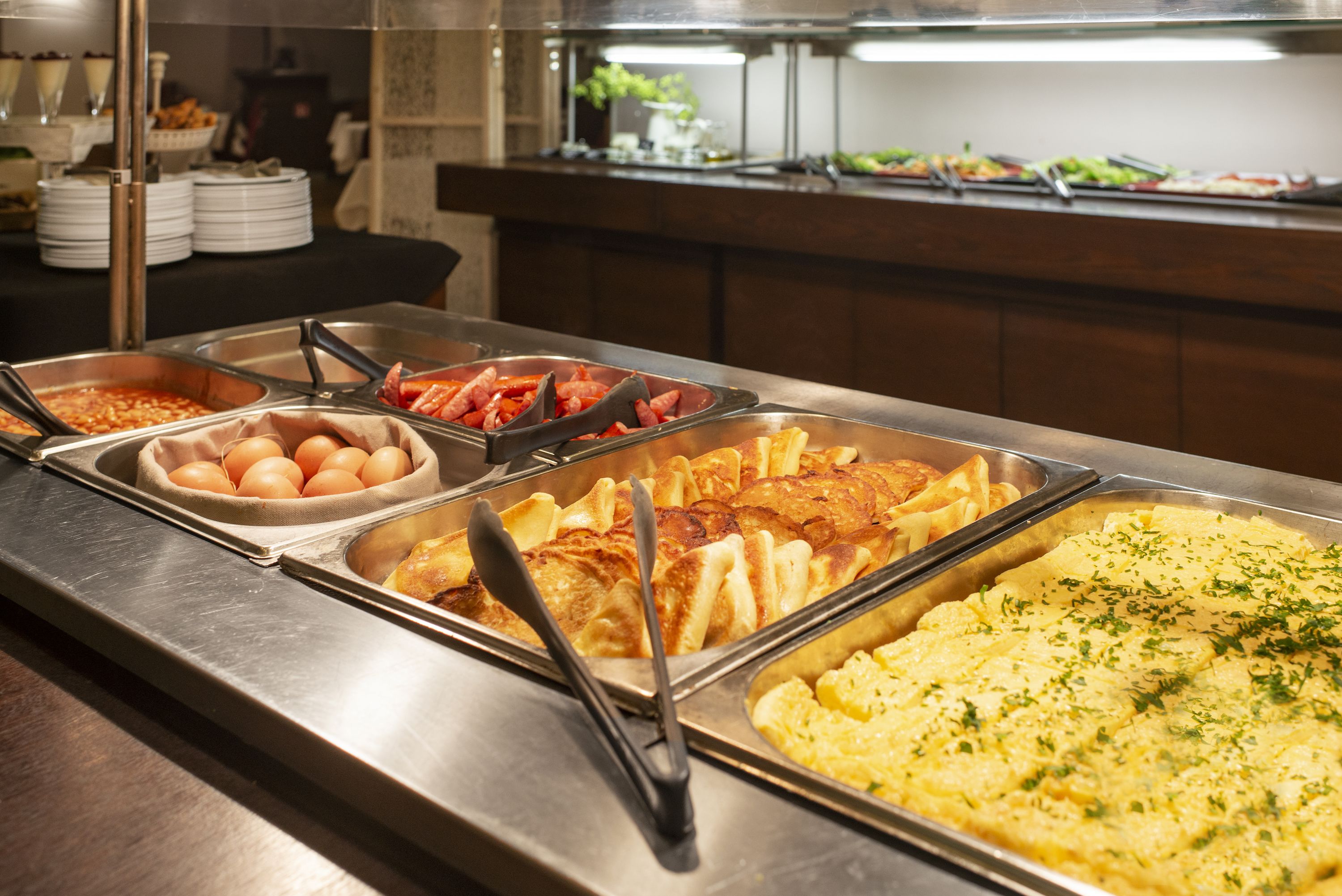 A buffet with various food items including eggs, shrimp, and a large omelette.