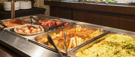 A buffet with various food items including eggs, shrimp, and a large omelette.