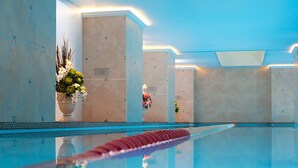 A modern indoor swimming pool with clear water, a red lane divider, and decorative flowers. - Amberton Hotel Klaipeda (Klaipeda)