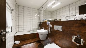 A modern bathroom with a bathtub, toilet, and sink.
