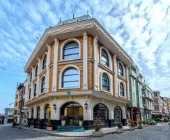 A corner building with a large arched entrance, multiple windows, and a balcony.