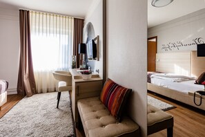 Relax in a cozy space with a comfortable bed, bedside table, and seating area.