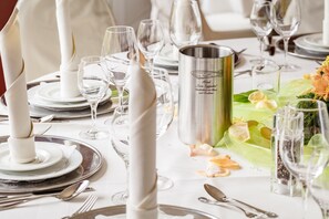 A beautifully set dining table awaits, complete with fine china, silverware, and elegant glassware.