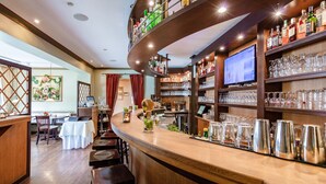 A bar area with a curved counter, multiple stools, a television screen, and shelves stocked with bottles and glasses. - Hotel Zum Zeppelin (Hamburg)