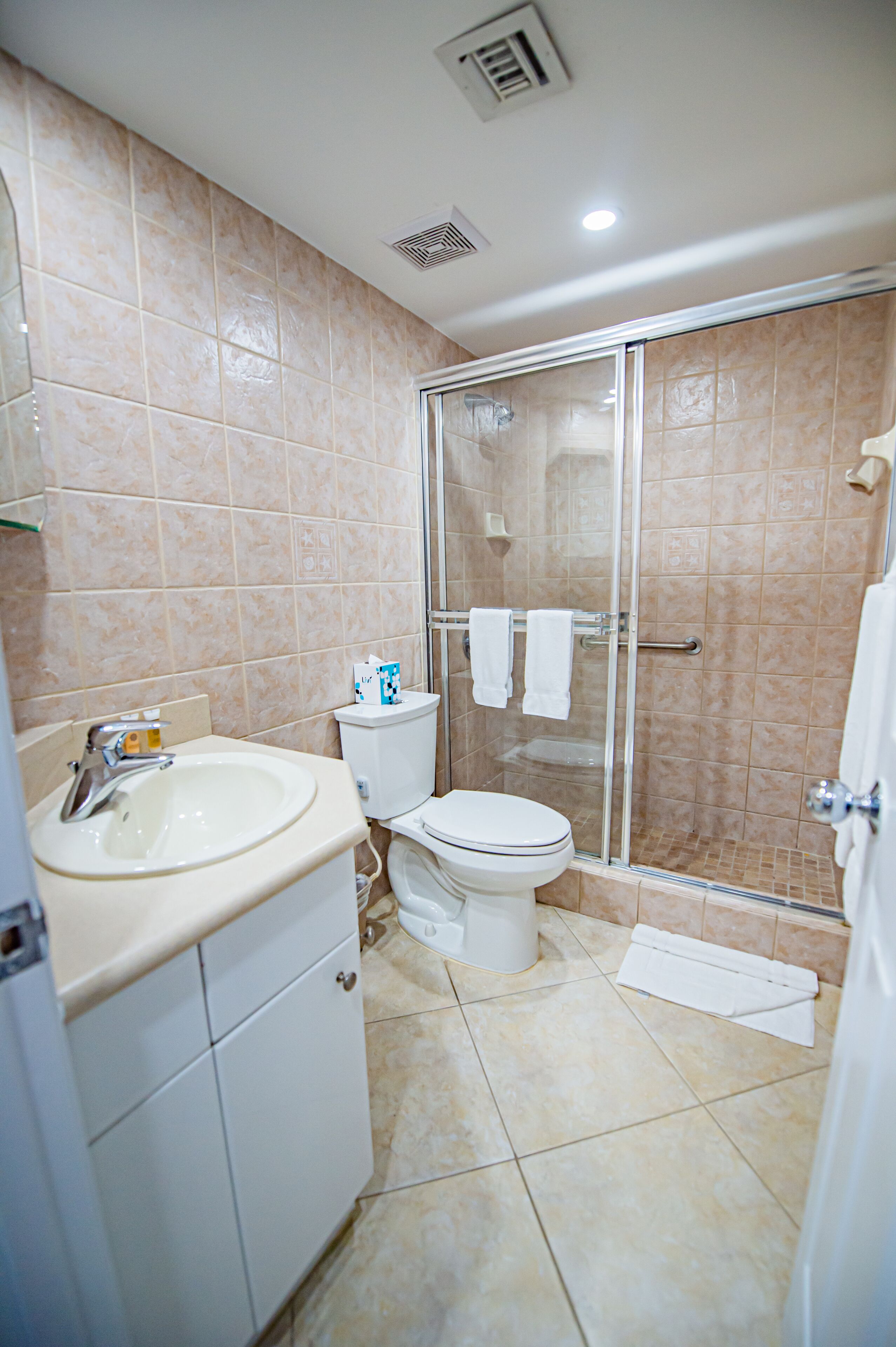 A bathroom with a sink, toilet, and glass-enclosed shower.