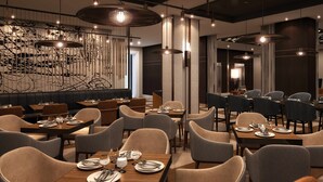 Ein modernes Restaurant-Interieur mit hohen Tischen, gemütlicher Sitzgelegenheit und stimmungsvoller Beleuchtung.