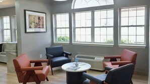 Una sala de estar moderna con chimenea, ventanas amplias y una mesa de centro redonda.