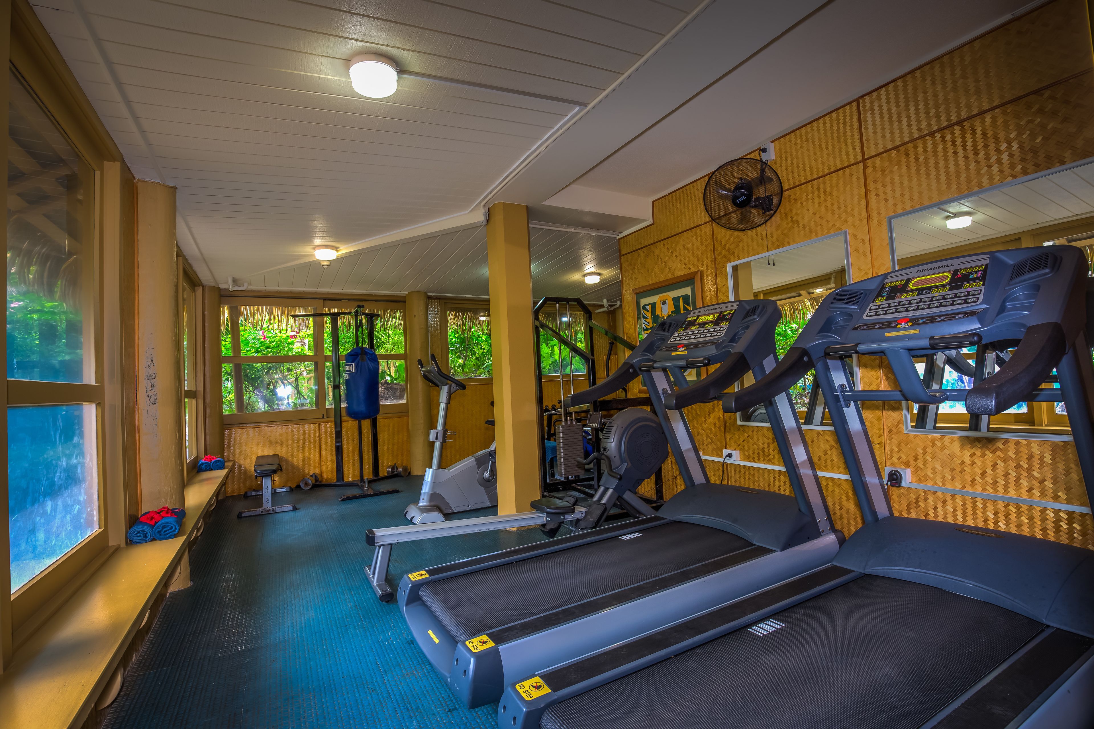 Een fitnessruimte met loopbanden, hometrainers en gewichten.
