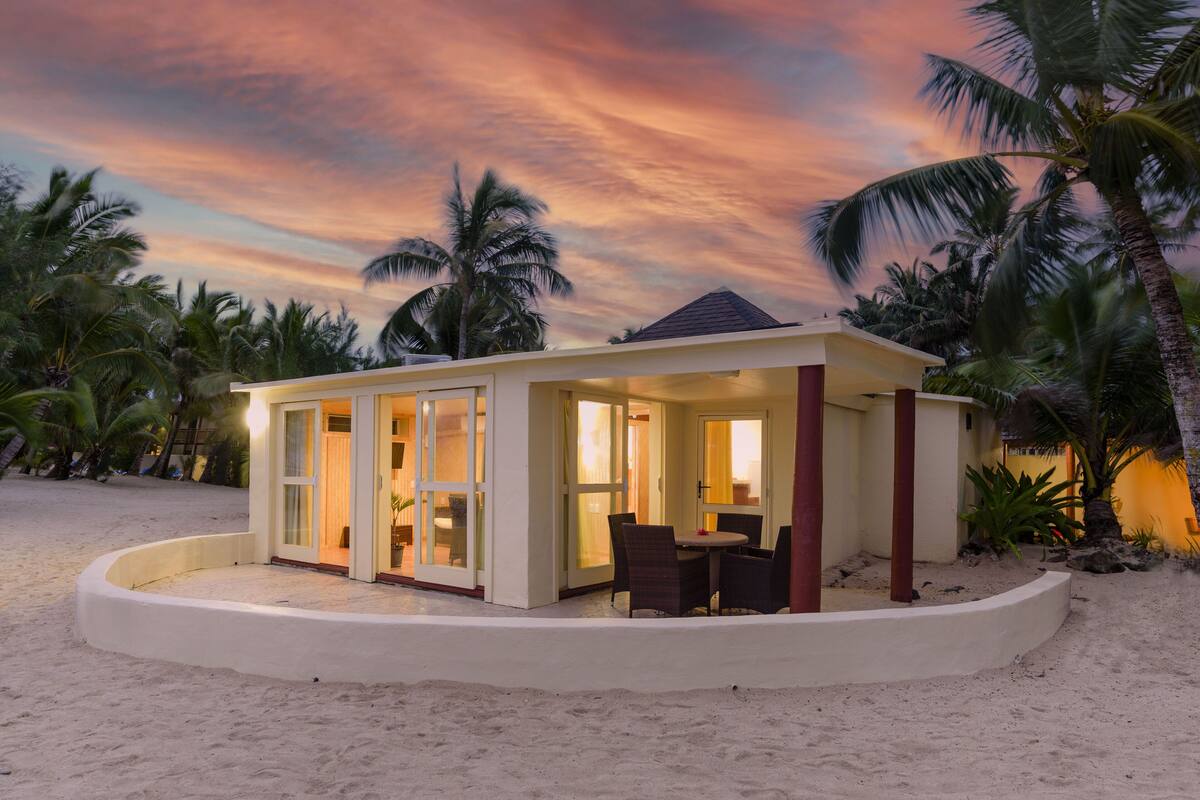 A beachfront property with a covered patio and a dining area.