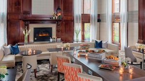 A spacious living room with a fireplace, comfortable seating, and a dining area with food and drinks.