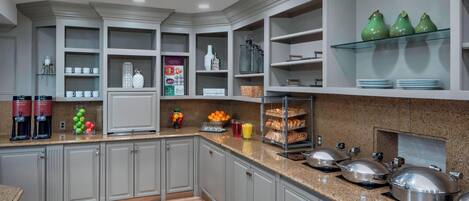 A modern kitchen with grey cabinets, a granite countertop, and various kitchen appliances.
