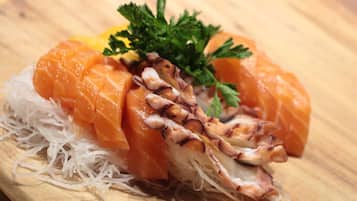 A sushi dish with salmon and octopus on a wooden board.