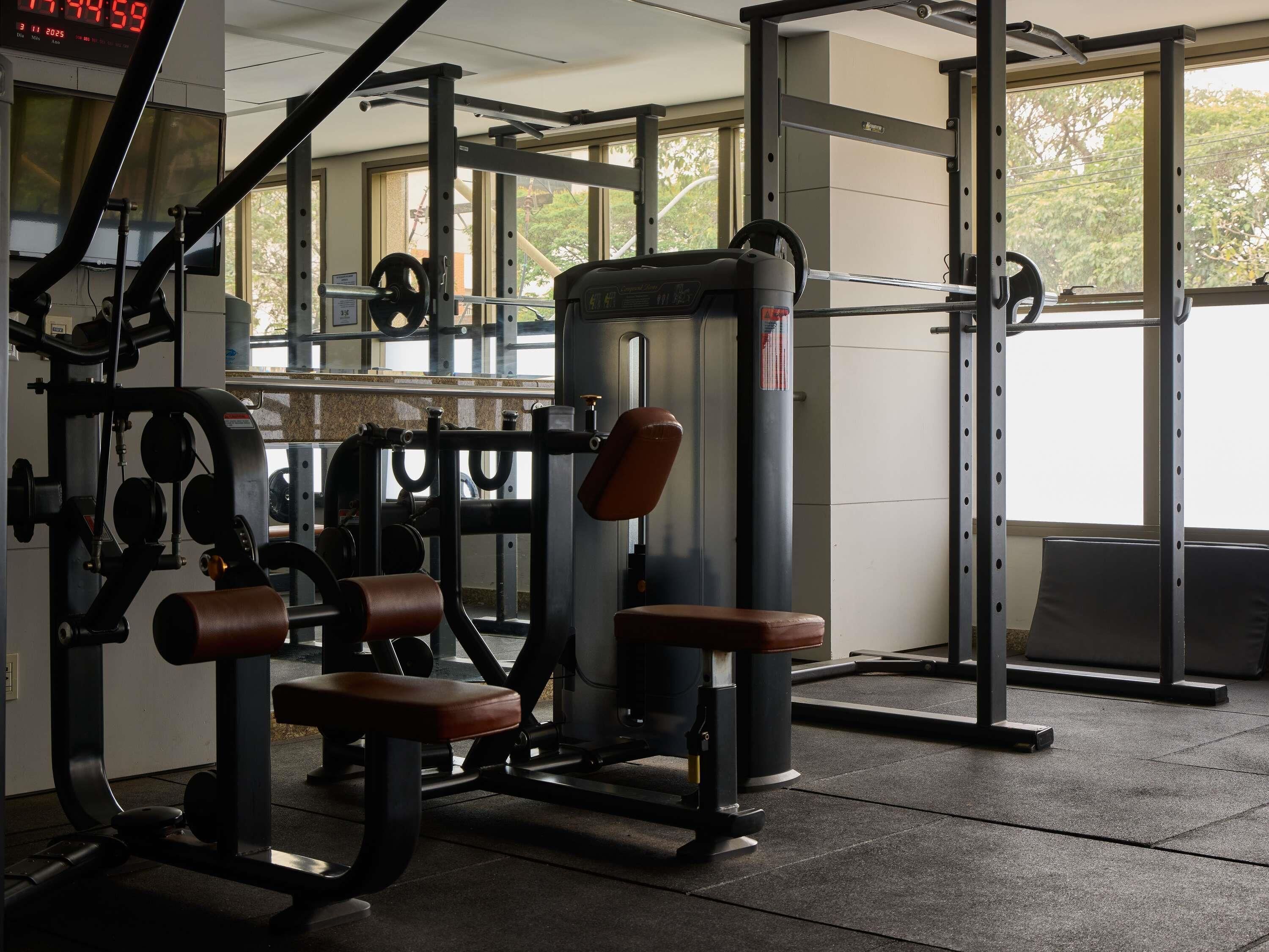 Een sportschool met gewichthefapparatuur, een bankdrukpers en een power rack.