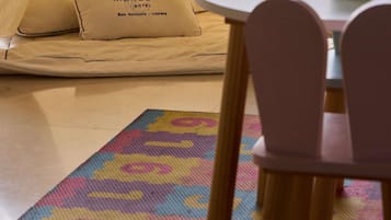 Cama com almofadas com a etiqueta 'Mercure Hotel' e um tapete colorido.