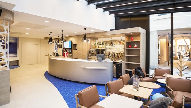 A modern hotel lobby with a reception desk, seating area, and bar. - ibis Styles La Rochelle Centre Vieux Port (La Rochelle)