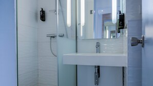 A modern bathroom with a glass shower enclosure, a white sink, and a mirror. - ibis Styles La Rochelle Centre Vieux Port (La Rochelle)