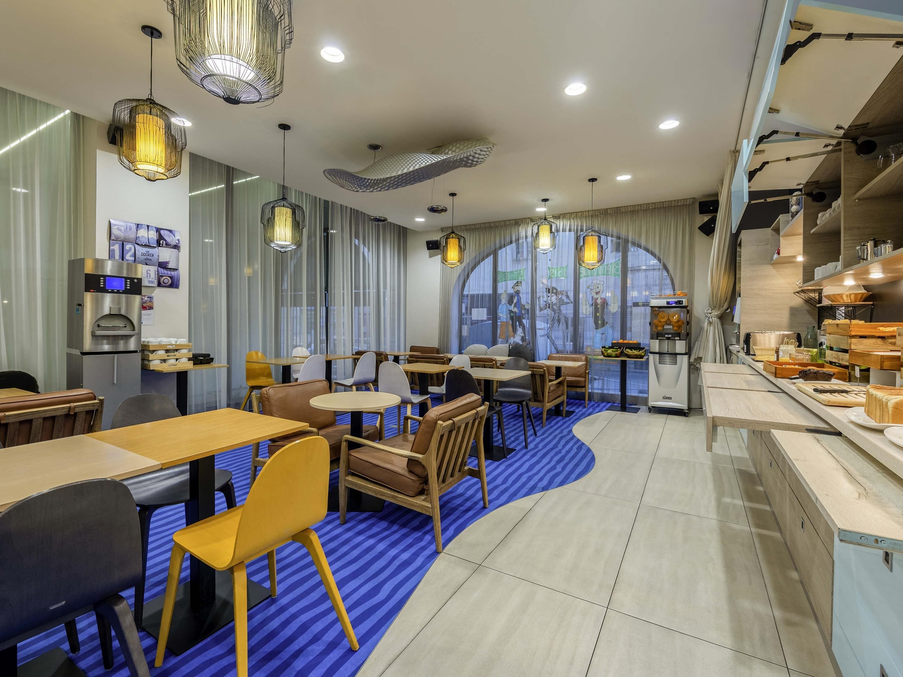 Un interior de restaurante moderno con mesas, sillas, una máquina de café y un amplio ventanal.