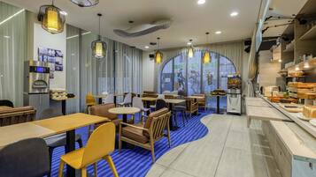 Un interior de restaurante moderno con mesas, sillas, una máquina de café y un amplio ventanal.