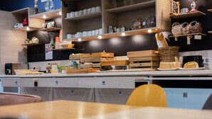 A kitchen area with wooden shelves, a chalkboard, and various kitchen utensils. - ibis Styles La Rochelle Centre Vieux Port (La Rochelle)