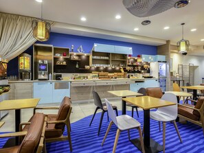 Una cafeteria moderna amb una decoració blau i blanca, que inclou una barra, seients i un sòl amb disseny.