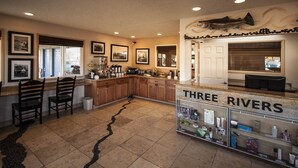 A kitchen with wooden cabinets, a granite countertop, and a display case labeled "THREE RIVERS". - Three Rivers Inn (Biggs Junction)