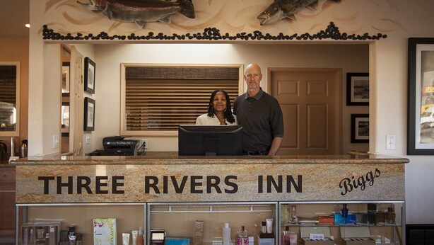 A reception desk at Three Rivers Inn with a sign reading "Three Rivers Inn" and "Biggs". - Three Rivers Inn (Biggs Junction)