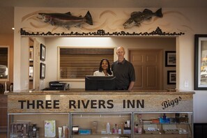 A reception desk at Three Rivers Inn with a sign reading "Three Rivers Inn" and "Biggs". - Three Rivers Inn (Biggs Junction)