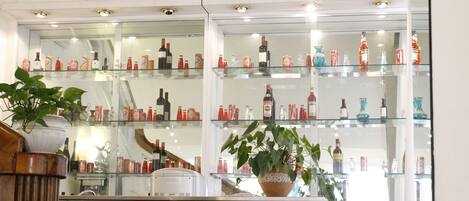 A bar area with multiple shelves displaying various bottles and glasses.
